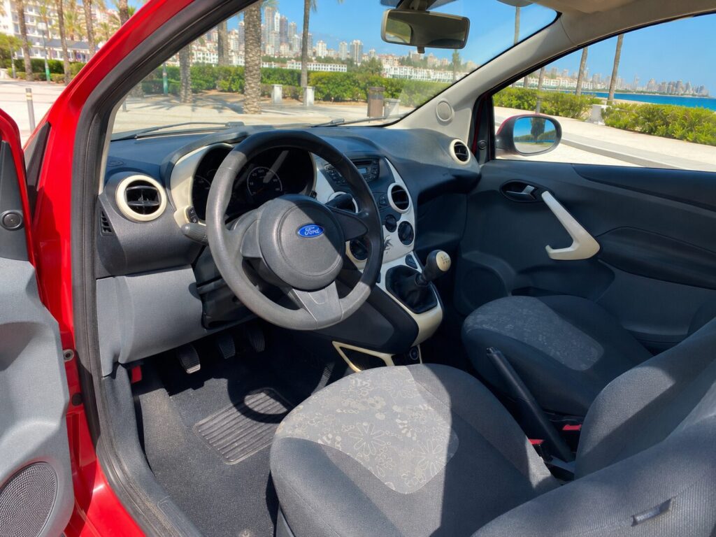 Ford Ka rojo junto al mar en Benidorm con recogida flexible